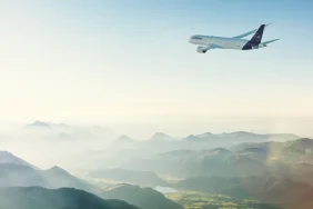 Lufthansa Group, Green Fare Tarifesinin Adını Impact Fare Olarak Değiştirdi Dağların üzerinde uçan Lufthansa yolcu uçağı
