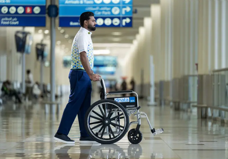 Dubai Havalimanı terminalinde tekerlekli sandalyeyle dnata çalışanı